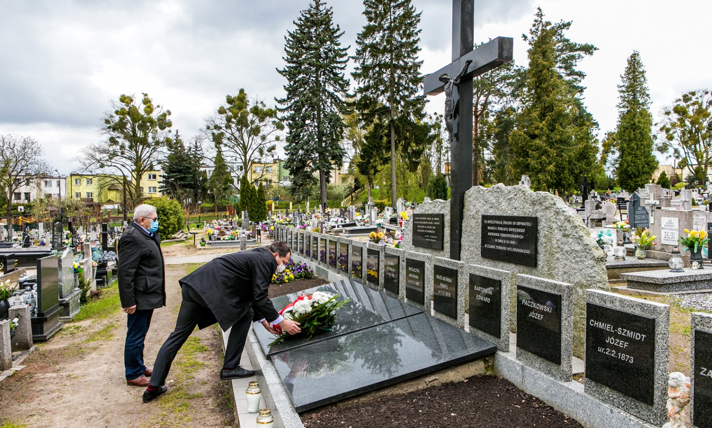 widok na cmentarz, zastępca Burmistrza i przewodniczacy Rady Miejskiej w Świeciu składają wiązankę na jednym z grobów