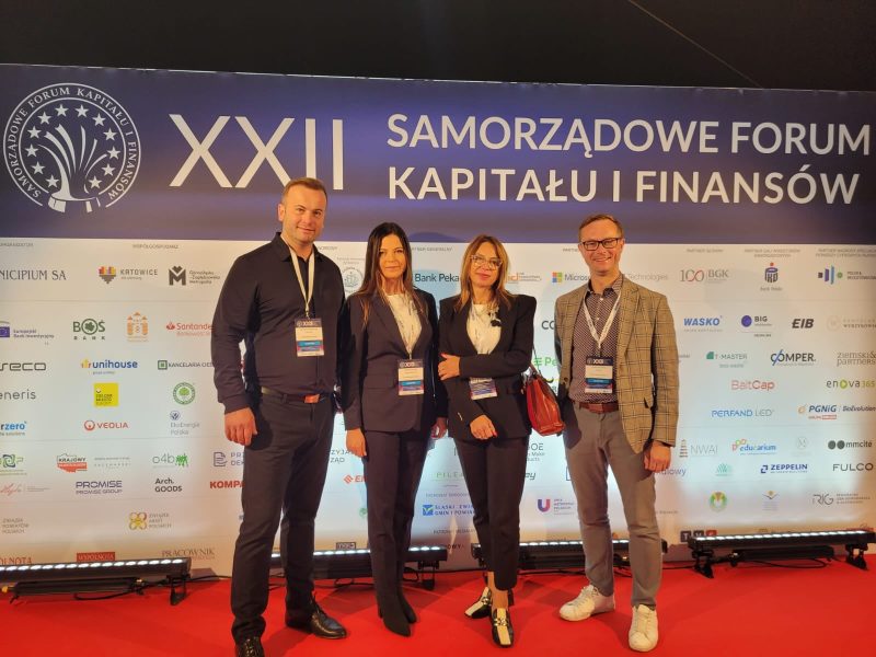 Na ściance XXII Samorządowe Forum Kapitału i Finansów od lewej stoją Burmistrz Świecia, II Zastępca Burmistrza Marta Karolczak, Skarbnik Gminy Marzenna Rzymek oraz Sekretarz gminy Jakub Kochowicz.